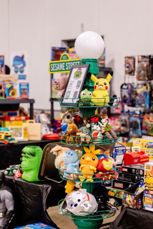 A creative Sesame Street lamppost display stacked with plush toys including Pikachu and Darth Vader